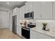 Modern kitchen with white cabinets, stainless steel appliances, and quartz countertops at 31564 Woodland Race Loop, Wesley Chapel, FL 33545
