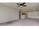 Bright living room featuring gray carpeting and a ceiling fan at 15215 Amberly Dr # 206, Tampa, FL 33647