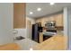Modern kitchen with light wood cabinets and black appliances at 15215 Amberly Dr # 206, Tampa, FL 33647
