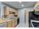 Kitchen with light wood cabinets and black appliances at 15215 Amberly Dr # 206, Tampa, FL 33647
