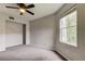 Simple bedroom with ceiling fan, window, and carpeting at 15215 Amberly Dr # 206, Tampa, FL 33647