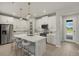 Modern kitchen with island, white cabinets and stainless steel appliances at 31556 Woodland Race Loop, Wesley Chapel, FL 33545