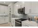 Bright kitchen with gray tile backsplash, stainless steel appliances, and white cabinets at 31556 Woodland Race Loop, Wesley Chapel, FL 33545
