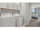 Convenient laundry room with washer, dryer, and built-in cabinets at 31556 Woodland Race Loop, Wesley Chapel, FL 33545