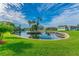 Serene lakefront view with lush landscaping and palm trees at 4229 Redcliff Pl # 4229, New Port Richey, FL 34652