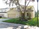 Two-story house with attached garage, mature tree, and manicured lawn at 10605 Marsanne Pl, Riverview, FL 33578