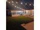 Night view of backyard with string lights, patio furniture and screened porch at 525 San Jose Dr, Dunedin, FL 34698