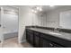 Bathroom with double sink vanity, granite countertops, dark cabinets, and tile flooring at 3147 Calvano Dr, Land O Lakes, FL 34639