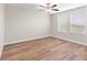 Bright bedroom featuring modern wood-look flooring, ceiling fan, and natural light at 3147 Calvano Dr, Land O Lakes, FL 34639