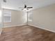 Bright bedroom featuring modern wood-look flooring, ceiling fan, and natural light at 3147 Calvano Dr, Land O Lakes, FL 34639