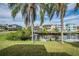 Picturesque waterfront backyard featuring a private dock and tranquil canal views framed by palm trees at 6001 Bayway Ct, New Port Richey, FL 34652