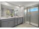 Double vanity bathroom with gray cabinets and a large walk-in shower at 31570 Woodland Race Loop, Wesley Chapel, FL 33545