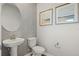 Stylish powder room with pedestal sink, patterned wallpaper, and modern fixtures at 31570 Woodland Race Loop, Wesley Chapel, FL 33545