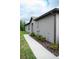 Gray house exterior with walkway, landscaping, and brown gutters at 14117 Weddington Ter, Hudson, FL 34669