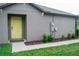 Front entrance with yellow door and landscaping at 14117 Weddington Ter, Hudson, FL 34669