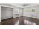 Bedroom with dark hardwood floors, large closet, and window with blinds at 2295 Americus E Blvd # 27, Clearwater, FL 33763