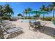 Resort-style pool with lounge chairs, tables, and umbrellas at 12000 Gulf Blvd # 206N, Treasure Island, FL 33706