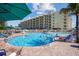 Resort-style pool with plenty of lounge chairs and beach umbrellas at 12000 Gulf Blvd # 206N, Treasure Island, FL 33706