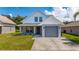 Charming two-story home with a gray garage, well-kept lawn and landscaping under blue skies at 10209 Summerview Cir, Riverview, FL 33578