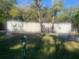 Exterior view of home with long yard, trees, and mailbox with address is a blank canvas at 10542 Helena St, New Port Richey, FL 34654