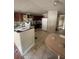 View of kitchen and dining area with tile flooring and wood cabinets at 10542 Helena St, New Port Richey, FL 34654
