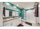 Modern bathroom with double vanity, shower, and teal walls at 15407 Miller Creek Dr, Sun City Center, FL 33573