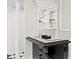 Stylish bar area with custom cabinetry, glass shelving, and black and white tile floors at 45 Adalia Ave, Tampa, FL 33606