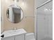 Bright bathroom with a round mirror, modern lighting, and glass-enclosed shower at 45 Adalia Ave, Tampa, FL 33606