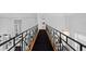 Upper hallway boasting black metal railing, wood floors, and elegant chandelier, adding sophisticated flair at 45 Adalia Ave, Tampa, FL 33606