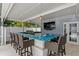 Spacious outdoor bar with sink, grill, and barstool seating, perfect for enjoying a meal by the pool at 45 Adalia Ave, Tampa, FL 33606
