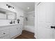 Clean bathroom with white vanity, marble shower, and wood-look floors at 10209 Summerview Cir, Riverview, FL 33578