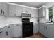 Modern kitchen with gray cabinets, marble countertops, and stainless steel appliances at 10209 Summerview Cir, Riverview, FL 33578