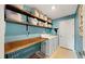 Laundry room with wooden shelves and a dog crate at 15407 Miller Creek Dr, Sun City Center, FL 33573