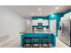Modern kitchen with teal accents and a large island with seating at 15407 Miller Creek Dr, Sun City Center, FL 33573