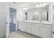 Bright bathroom featuring a double vanity, large mirror, and tile flooring at 4285 Big Sky Dr, Spring Hill, FL 34604