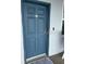 Condo building entry with a blue door and neutral color scheme at 445 Hamden Dr # 505, Clearwater Beach, FL 33767