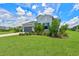 Two-story house with gray siding, landscaping, and palm trees at 13769 Old Creek Ct, Parrish, FL 34219