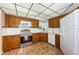 Traditional kitchen featuring wooden cabinets, white appliances, and tile flooring at 11705 66Th N Ave, Seminole, FL 33772