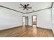 A large bedroom with wood-look tile flooring and ceiling fan shows entry to bathroom and another room at 281 Villa Corte Dr, Lutz, FL 33549
