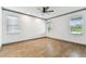Empty bedroom showcases hardwood floors, ample natural light, and a contemporary ceiling fan at 281 Villa Corte Dr, Lutz, FL 33549