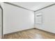 Empty bedroom featuring wood-look tile flooring, white walls, crown molding, and natural light at 281 Villa Corte Dr, Lutz, FL 33549