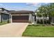 Charming home featuring a well-manicured lawn, driveway, and two-car garage at 281 Villa Corte Dr, Lutz, FL 33549