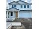 Two-story home with black trim windows and a large two car garage at 318 W Park Ave, Tampa, FL 33602