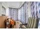 Sunroom with striped chair and boxes at 7154 El Meyers St, Zephyrhills, FL 33541