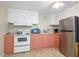 Pink and white kitchen with appliances at 7154 El Meyers St, Zephyrhills, FL 33541