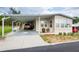 Tan mobile home with carport at 7154 El Meyers St, Zephyrhills, FL 33541