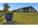 Home's backyard features a covered patio and lush landscaping at 281 Villa Corte Dr, Lutz, FL 33549
