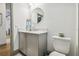 Clean bathroom with gray vanity, toilet, and round mirror at 281 Villa Corte Dr, Lutz, FL 33549