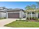 Modern house exterior featuring a two-car garage and landscaping at 281 Villa Corte Dr, Lutz, FL 33549