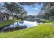 Serene pond with lush green grass and tree-lined edges at 4474 Connery Ct, Palm Harbor, FL 34685